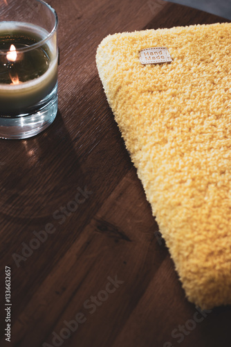 Obraz na płótnie Yellow knitting book cover with word handmade and glowing candle. Craft product. Fluffy knitted book cover. Knitting hobby. Handmade knitted clothing. Cozy still life. w salonie