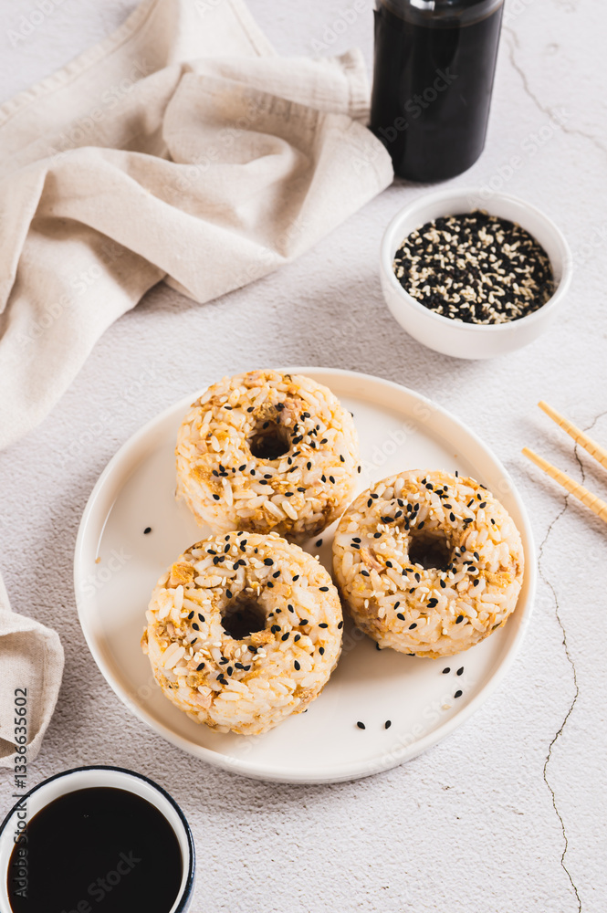Rice donuts with meat and sesame seeds on a plate on the table vertical view