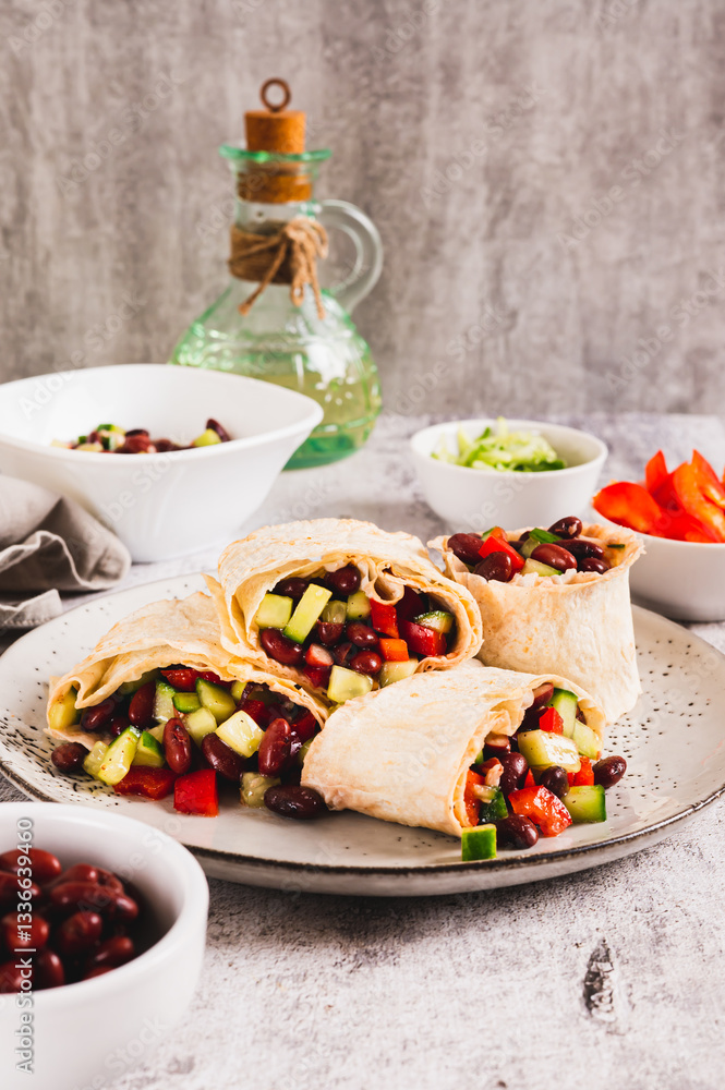 Salad of beans, cucumber and pepper in lavash rolls on a plate on the table vertical view