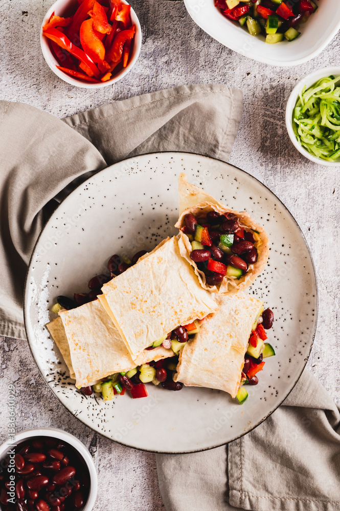 Vegetarian salsa rolls in tortilla on plate on table top and vertical view
