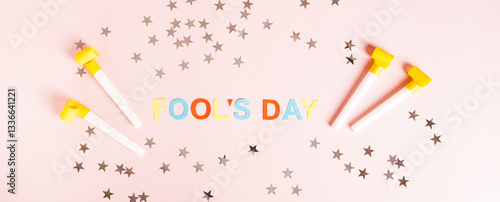 Obraz na płótnie April Fools' Day written in colored letters, whistles and stars on pink top view web banner w salonie