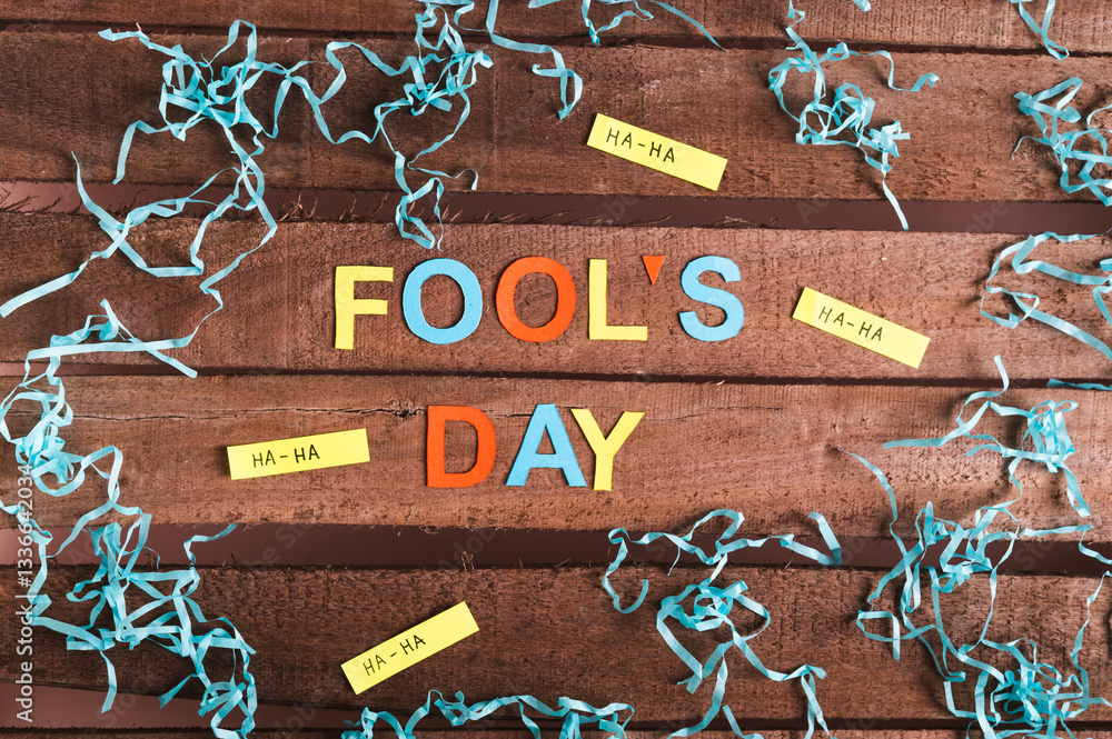 April Fools Day made of colored letters, funny notes and paper on wooden background