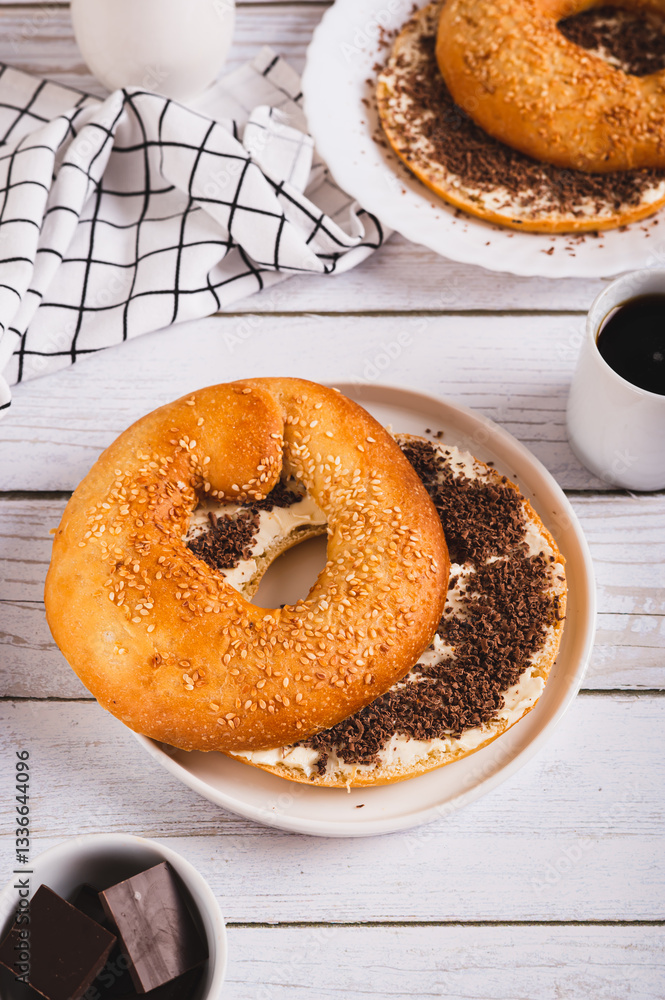 Sweet sandwich with butter, chocolate and sesame seeds on a plate on a table vertical view