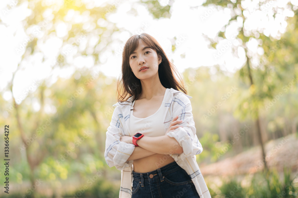 Asian woman enjoying summer outdoors, breathing fresh air with confident expression, surrounded by lush greenery and sunlight Asian woman enjoying summer outdoors, breathing fresh air with confident expression, surrounded by lush greenery and sunlight