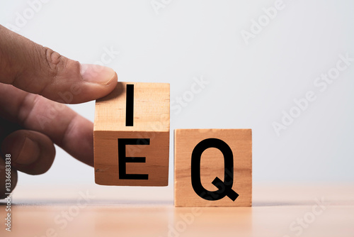Fotografie Hand flipping wooden block cube for balance between intelligence quotient (IQ) and emotional intelligence (EQ) concept