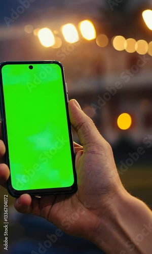 Smartphone with Vibrant Green Screen Held in a Packed Sports Stadium During a Live Event, Perfect for Mockups, Branding, and Digital Compositing