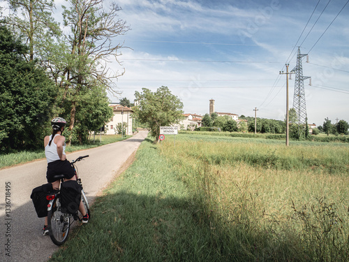 Cuadro en lienzo A cyclist pauses on a rural road along the Alpe Adria bike trail near Udine, Italy