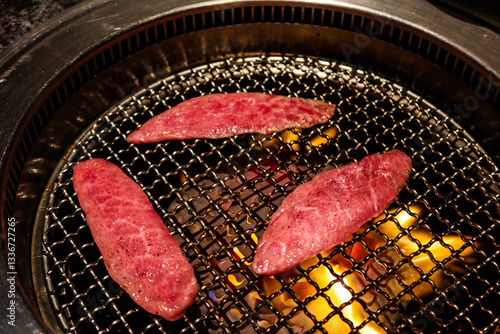 grilled three pieces of raw Japanese wagyu beef yakiniku on the stove
