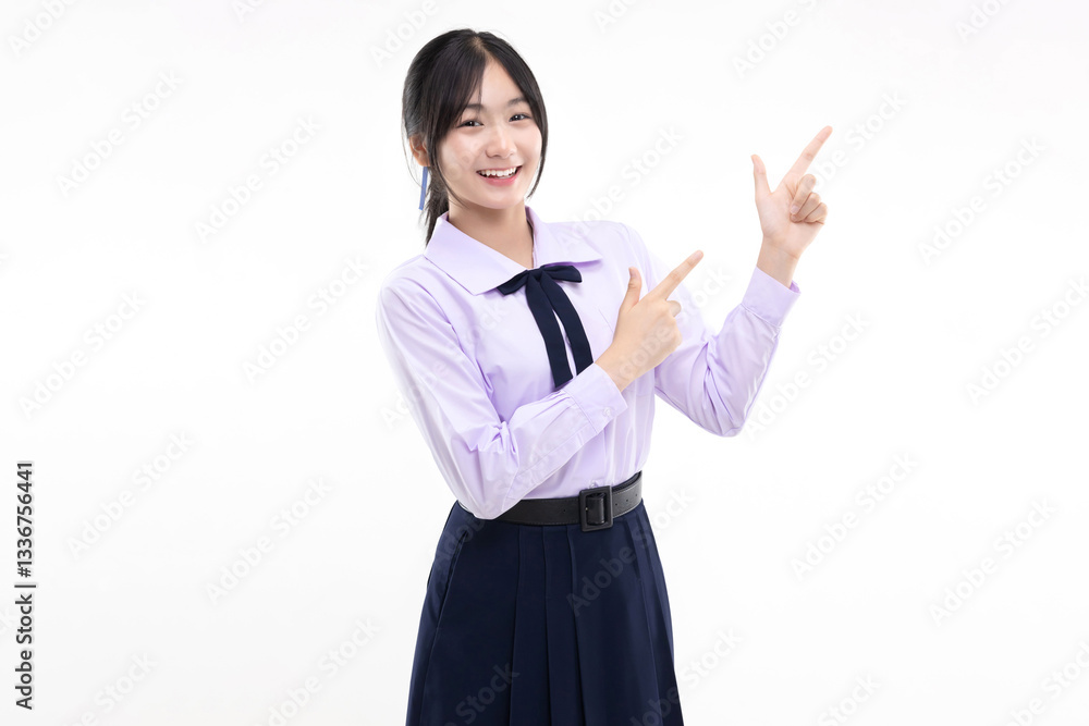 Happy pretty Asian student girl in school uniform pointing finger up isolated on white background. Happy pretty Asian student girl in school uniform pointing finger up isolated on white background.