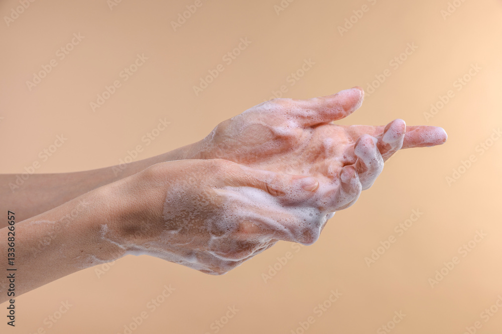 Woman washing hands with foaming soap on beige background, closeup. Hygiene Woman washing hands with foaming soap on beige background, closeup. Hygiene