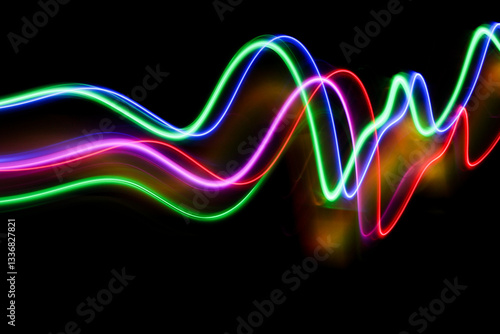 A long exposure photograph of colourful lights in swirl patterns of motion against a black background