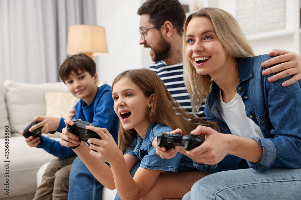 Fototapeta premium Happy family playing video games on sofa at home, selective focus