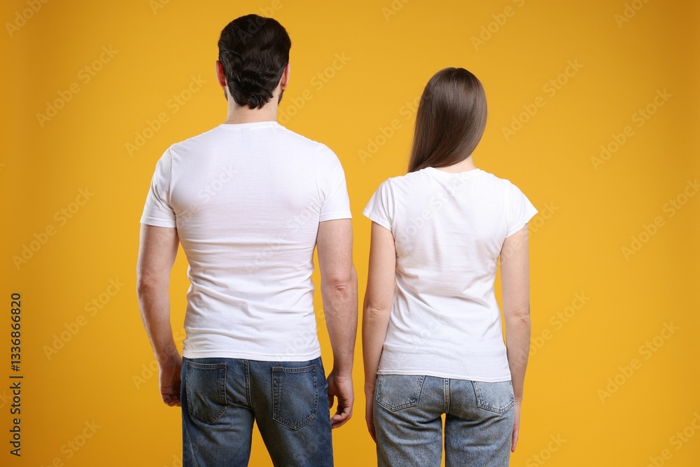 Woman and man wearing blank white t-shirts on orange background, back view. Mockup for design Woman and man wearing blank white t-shirts on orange background, back view. Mockup for design