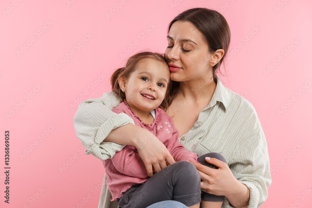 Portrait of mother with her cute daughter on pink background Portrait of mother with her cute daughter on pink background