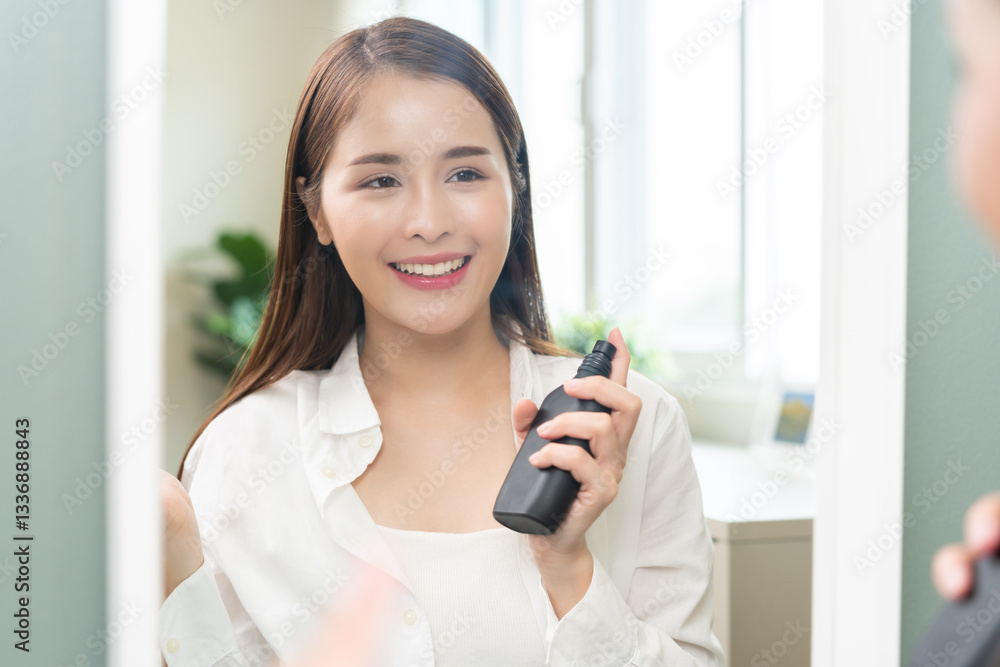 Perfume of essential aroma, beauty fashion concept. attractive perfect asian young woman holding perfume bottle, using spray and applying fragrance, scent at neck on body in front of mirror at home. Perfume of essential aroma, beauty fashion concept. attractive perfect asian young woman holding perfume bottle, using spray and applying fragrance, scent at neck on body in front of mirror at home.