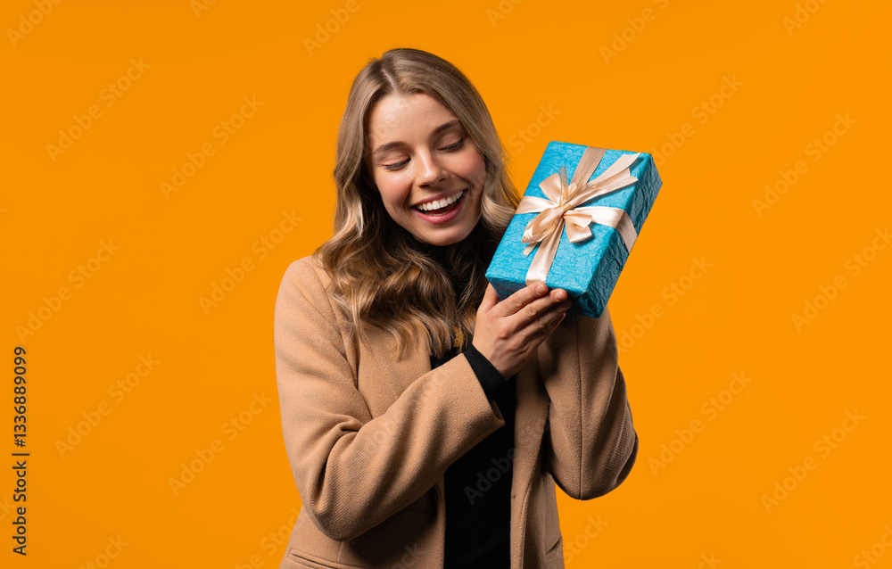 Happy stylish businesswoman gift box, yellow background. Lady smiling,interested Happy stylish businesswoman gift box, yellow background. Lady smiling,interested