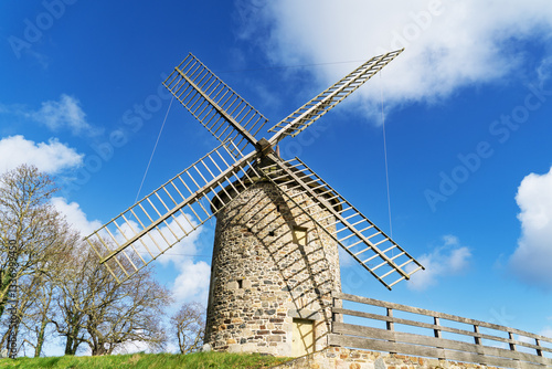 Le Moulin de Merlet à Plourhan se dresse fièrement sous un ciel bleu d'hiver, entouré d’une nature paisible et lumineuse.
