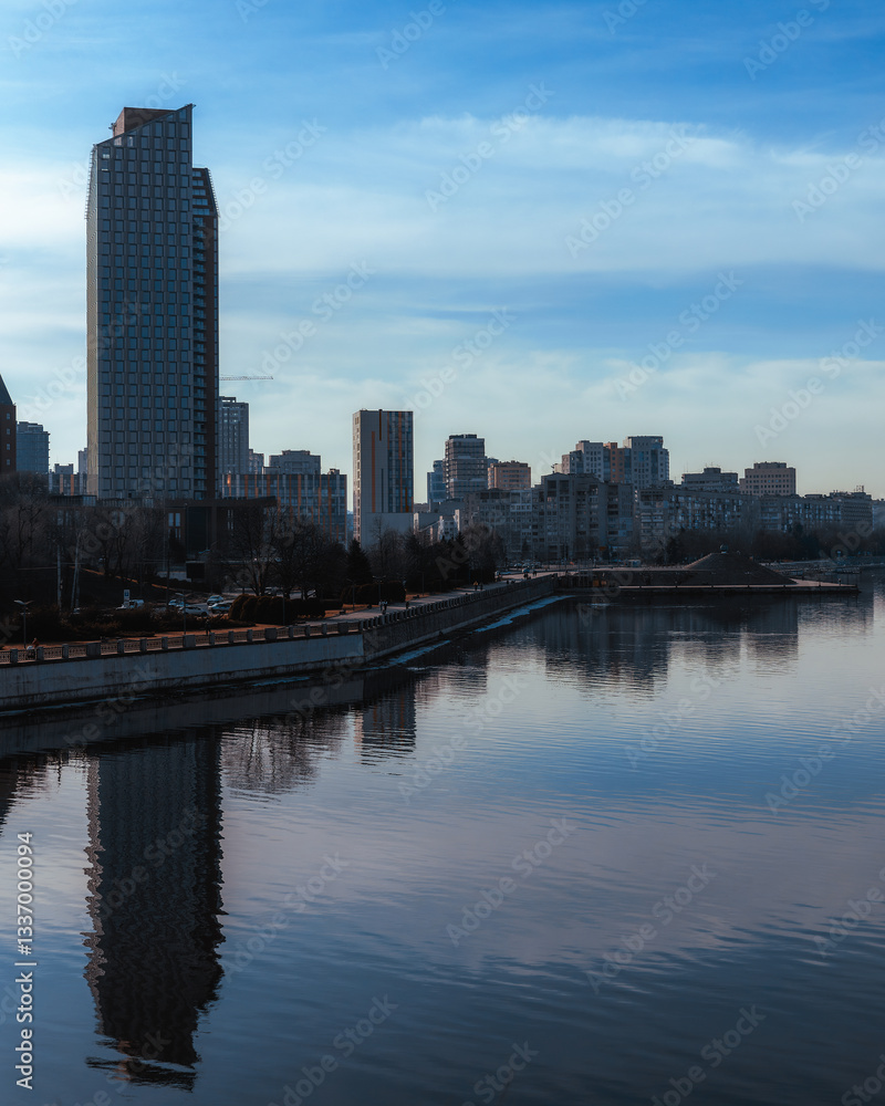 Cityscape with river and buildings reflected, panoramic view. Silhouettes of buildings are visible against the sky. Ukrainian city of Dnepr
Cityscape with river and buildings reflected, panoramic view. Silhouettes of buildings are visible against the sky. Ukrainian city of Dnepr