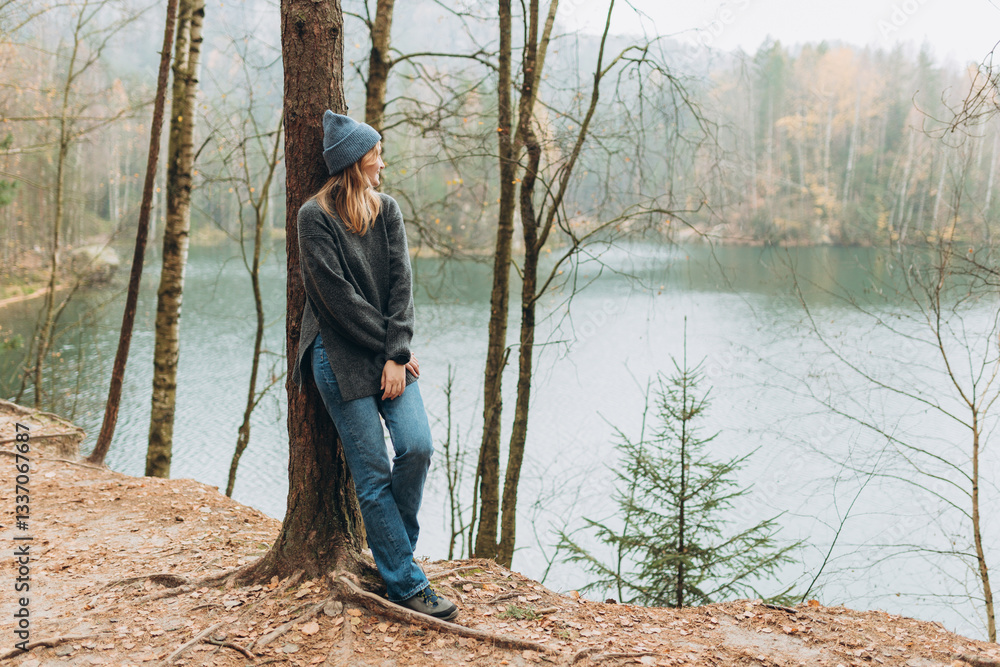 Fall autumn hiker woman outdoor at nature forest and lake for camping travel. Scenery of the majestic lake. Active lifestyle. Travel concept. High quality photo. Full body