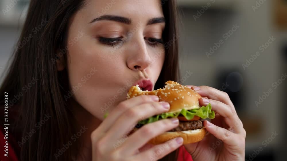 Pretty young woman eating a yummy hamburger for snacks Pretty young woman eating a yummy hamburger for snacks