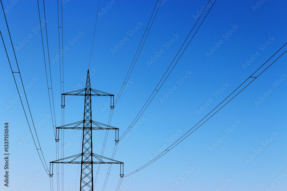 Bottom-up view of an electrical transmission line with blue sky in the background Bottom-up view of an electrical transmission line with blue sky in the background