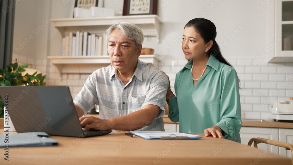 Obraz premium Grandmother comforting and supporting grandfather while looking at laptop show successful project and getting promotion. Happy senior businessman receive good news and talking to his wife. Myrmidon.