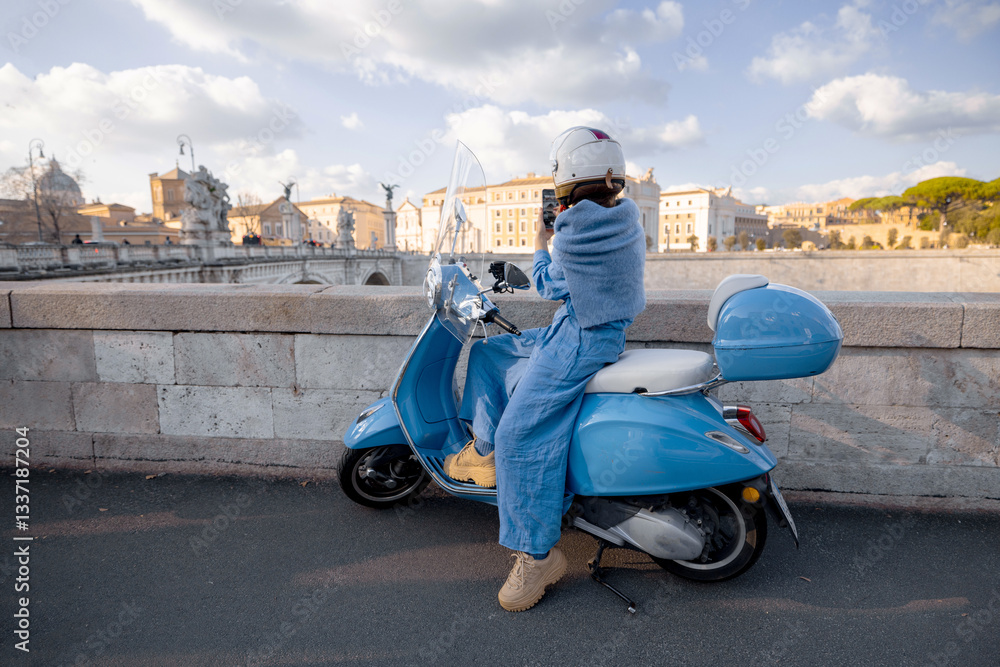 A woman in a blue outfit and helmet sits on a scooter, gazing at the scenic view of Ponte Sant Angelo in Rome. A perfect representation of adventure, independence, and European travel