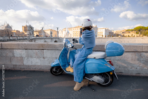 Obraz na płótnie A woman in a blue outfit and helmet sits on a scooter, gazing at the scenic view of Ponte Sant Angelo in Rome. A perfect representation of adventure, independence, and European travel w salonie