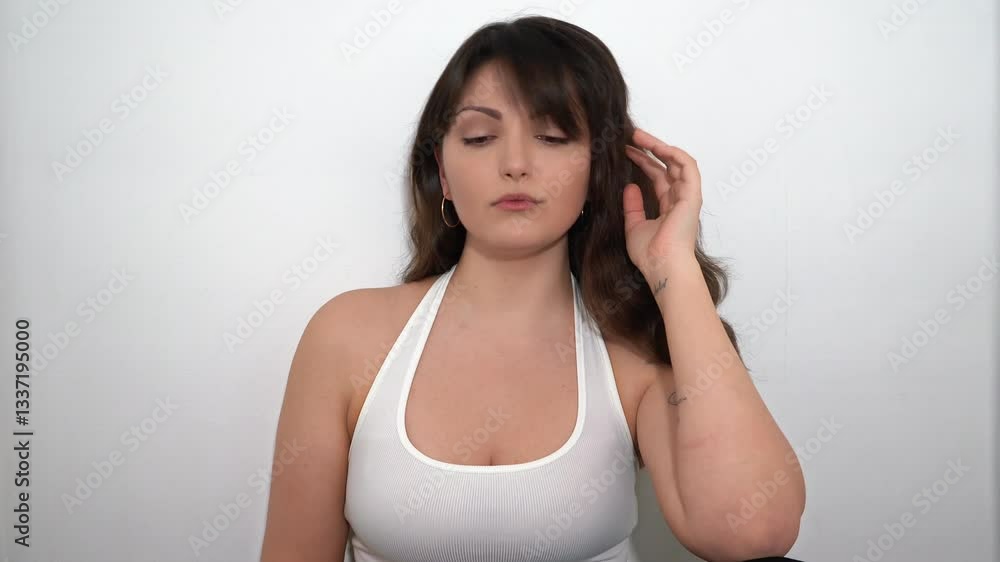Sad Young Brunette Woman With Tattoo Posing On The White Background In The Studio Sad Young Brunette Woman With Tattoo Posing On The White Background In The Studio