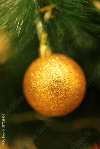 Golden New Year's ball on the Christmas tree. Beautiful shiny decoration.