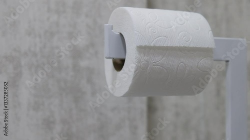 Close-Up of a Hand Pulling Paper Towels from a Dispenser in a Bathroom or Kitchen