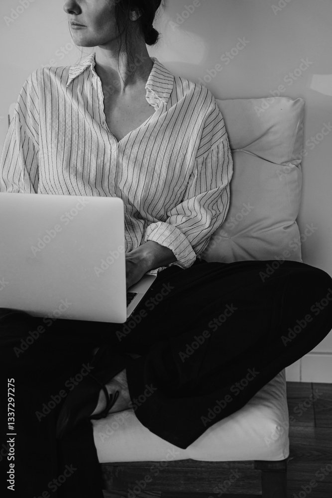 Fototapeta premium Working from Home. Woman Typing on Laptop in Minimalist, with Relaxed Vibes. Monochrome, Black and White