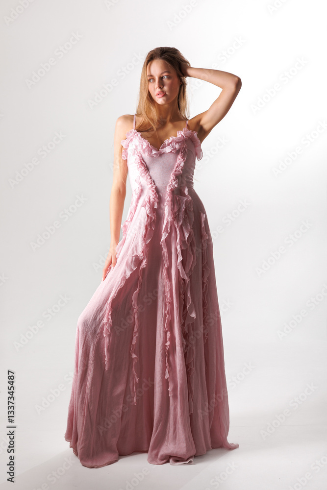 Elegant model showcases a stylish pink gown with delicate ruffles in a minimalist studio setting during daytime Elegant model showcases a stylish pink gown with delicate ruffles in a minimalist studio setting during daytime