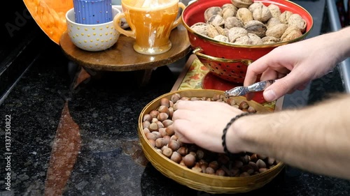 Nut Cracking in the Kitchen – Close-Up of Hazelnuts and Cracker on the Counter
