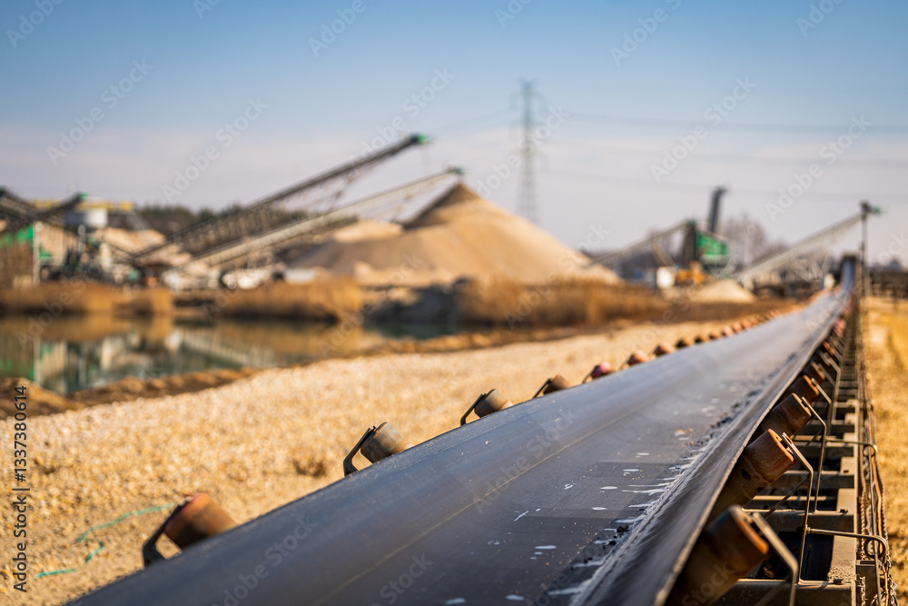 heavy duty conveyor belt - open pit mine and sand mining in the background - raw material transport