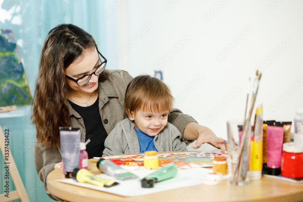 Fototapeta premium Mother and son painting together in their room