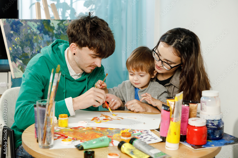 Fototapeta premium Young family with their son painting and having fun in the room