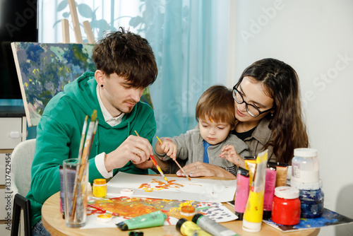 Young family with their son painting and having fun in the room
