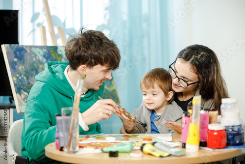 Young family with their son painting and having fun in the room