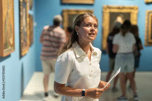 Εκτύπωση καμβά Museum female visitor with paper in hands walk through exhibition halls museum