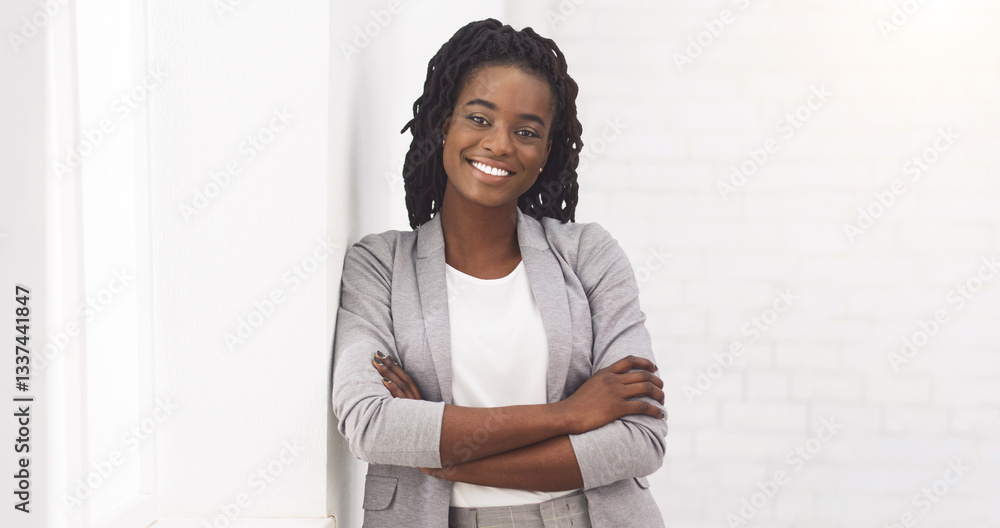 African American Pretty Businesswoman Standing Near Window In Office And Looking At Camera, Smiling African American Pretty Businesswoman Standing Near Window In Office And Looking At Camera, Smiling
