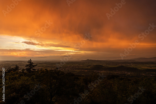 Obraz na płótnie vista panoramica su parte del territorio tra pianura e collina, nella regione Friuli Venezia Giulia, dopo un temporale estivo, al tramonto, con le nuvole colorate di arancione dalla luce del sole w salonie
