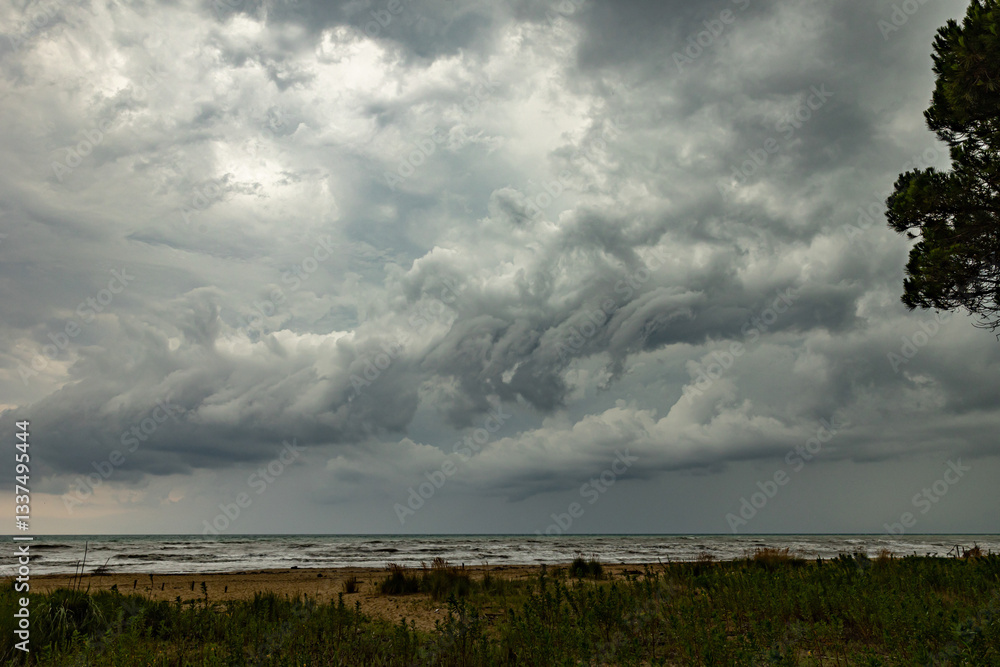 intenso temporale estivo mentre passa sopra il mare Adriatico, visto dalla costa del Veneto, di pomeriggio, in estate