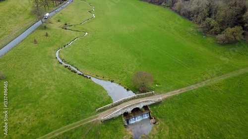 Scenic Aerial View of Rolling Green Fields and Meandering Stream in Yorkshire Countryside