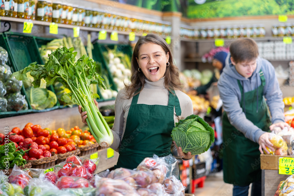 Positive girl seller with cabbage in her hands in the grocery department of the supermarket Positive girl seller with cabbage in her hands in the grocery department of the supermarket