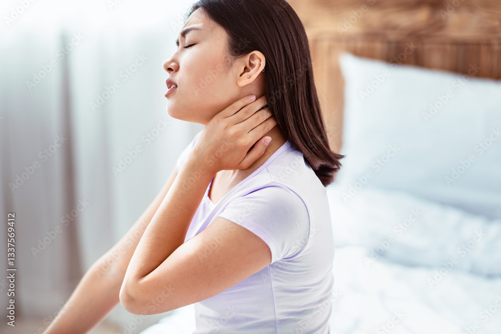 Arthritis Concept. Korean Woman Having Neck Pain Touching Aching Joint Sitting In Bed At Home. Arthritis Concept. Korean Woman Having Neck Pain Touching Aching Joint Sitting In Bed At Home.