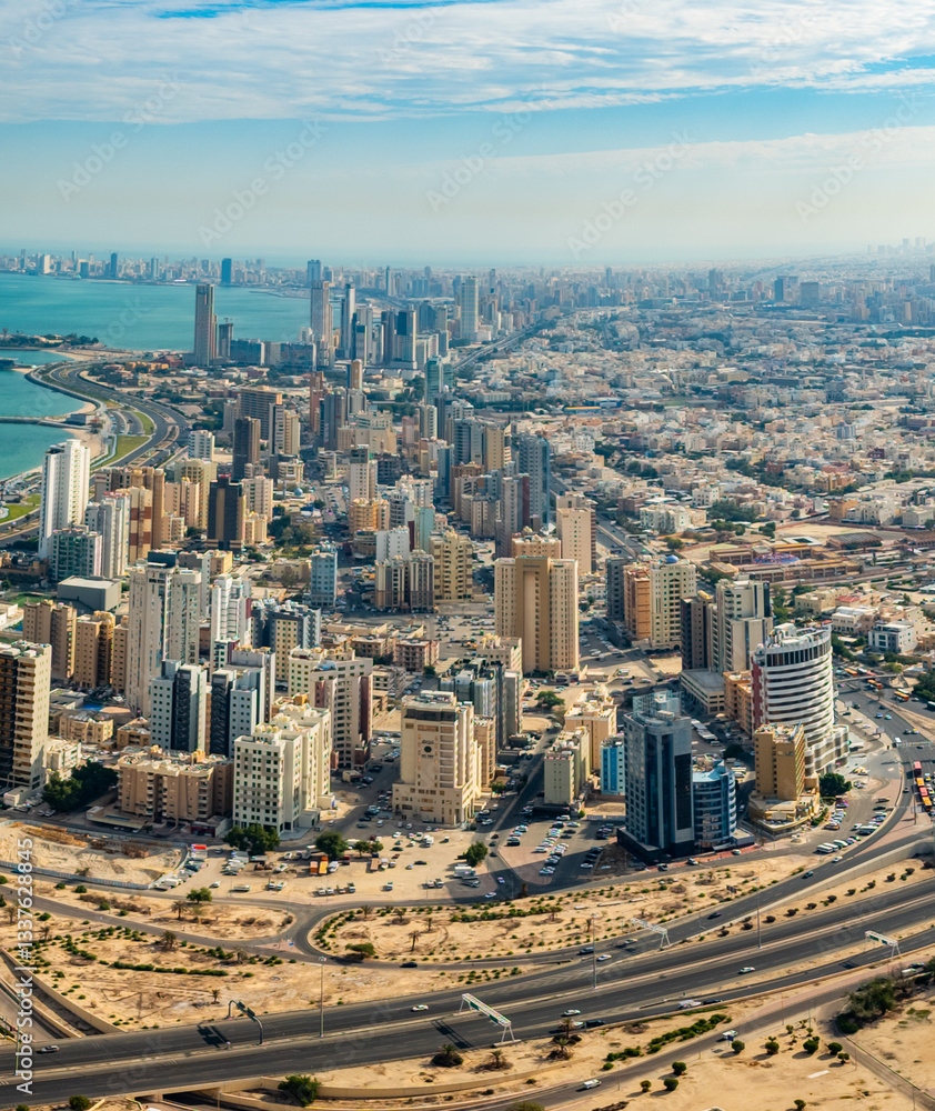 Fototapeta premium Aerial View of Kuwait City Skyline with High-Rise Buildings, Coastal Road, and Urban Landscape on a Clear Day – Kuwait