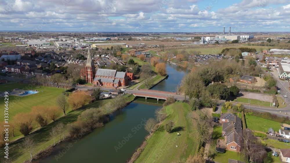 Aerial view of small town and church along a river in England UK Europe on a sunny day traffic crossing bridge countryside Aerial view of small town and church along a river in England UK Europe on a sunny day traffic crossing bridge countryside