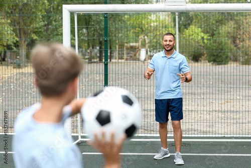 Father and son playing socc...