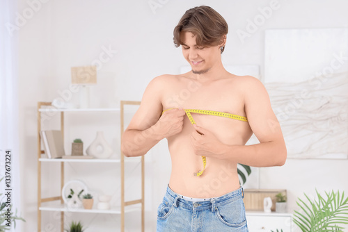 Young man measuring his che...